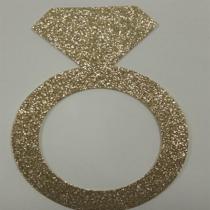 El papel del brillo del anillo del cartón del brillo pone letras al color oro para la decoración de la torta de cumpleaños